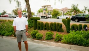 man standing in front of thank you hedges