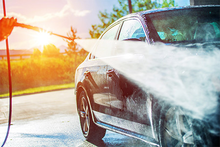 Person Pressure Washing Their Car